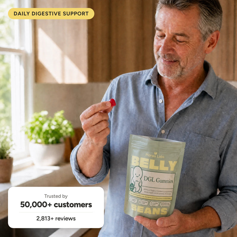 Woman holding Belly Beans DGL gummies in her kitchen
