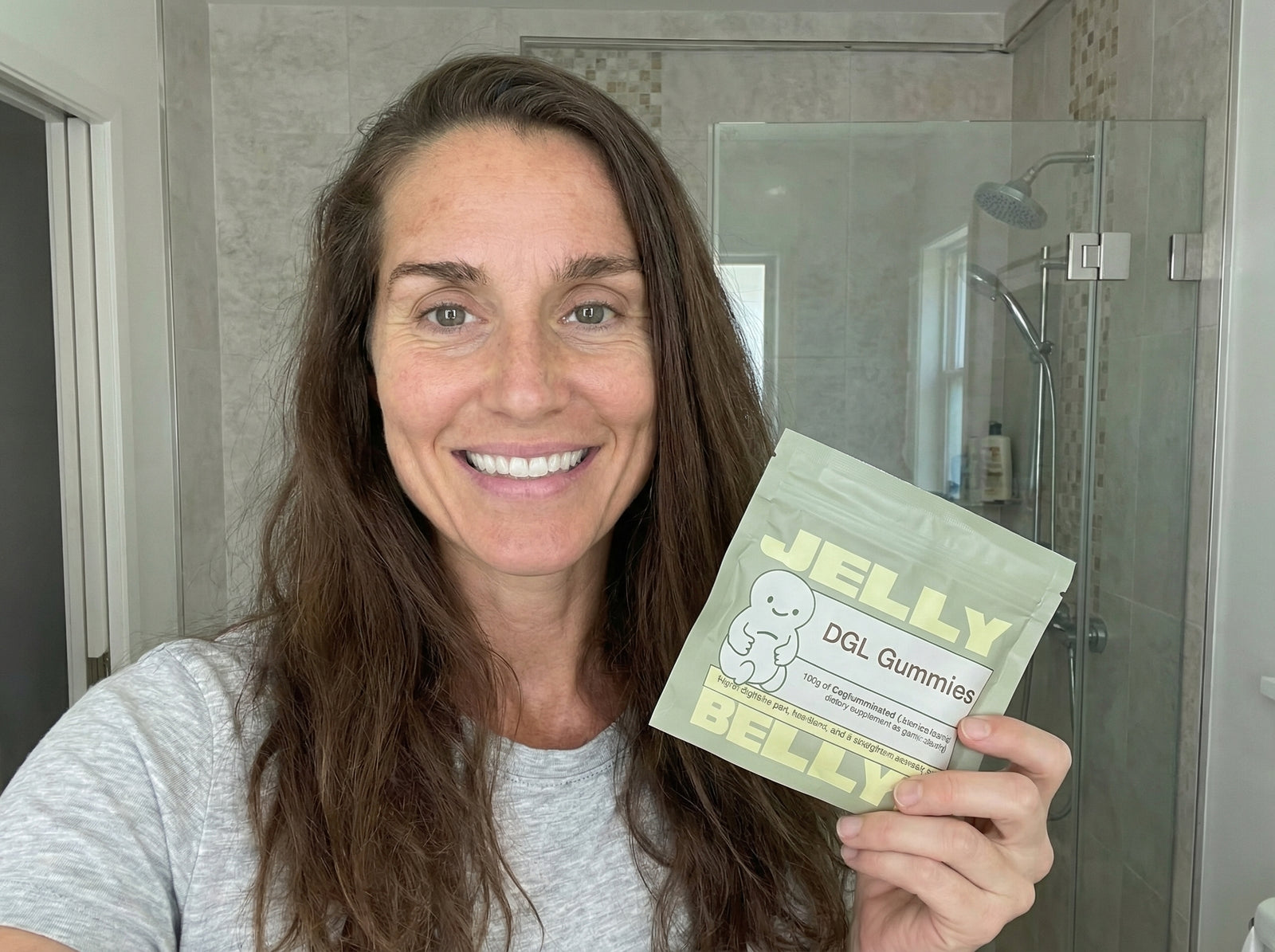 Woman holding Belly Jellys DGL gummies in her kitchen